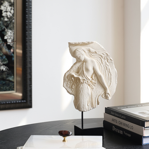 Decorative sculpture on a table with books and jewelry in the background