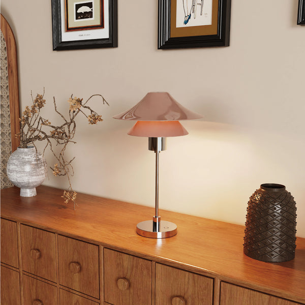 Table lamp on a wooden surface with decorative vases and branches.